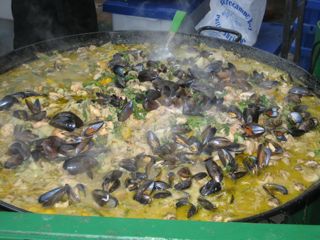 This is a 4' diameter pan of seafood paella, cooking away on a gas burner.